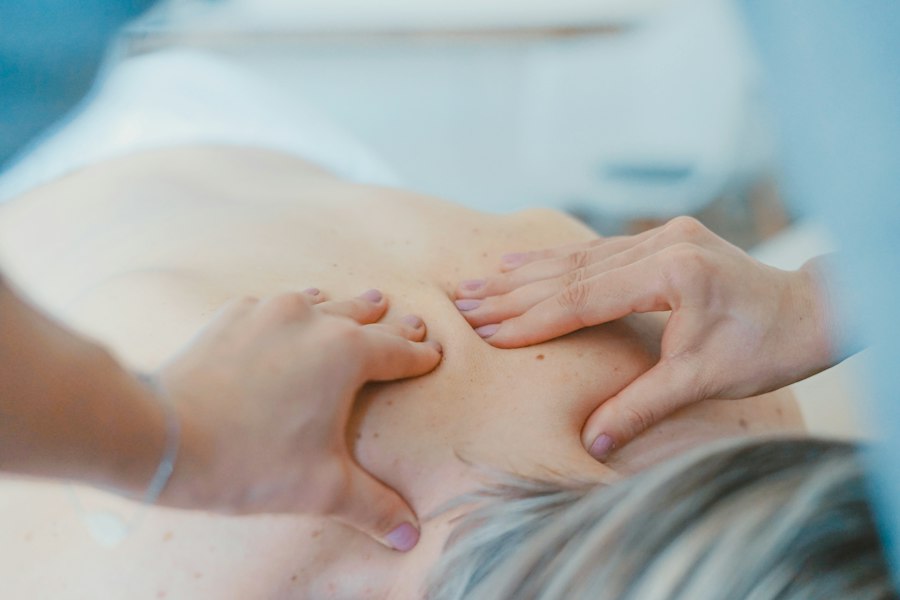 Hands working on the muscles of a patient's upper back